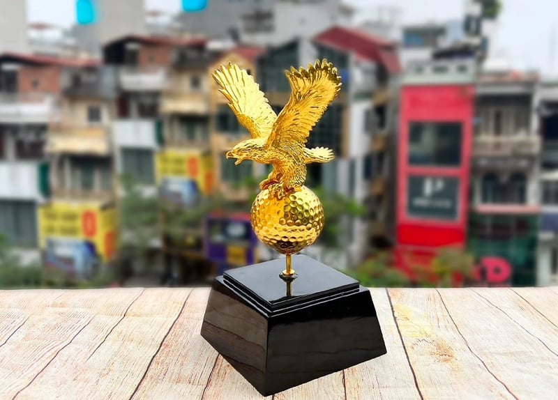 Hình ảnh chim đại bàng đậu trên quả bóng golf mạ vàng